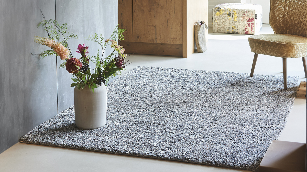Non-slip backed area rug laid flat on a hardwood floor in a bright, modern room